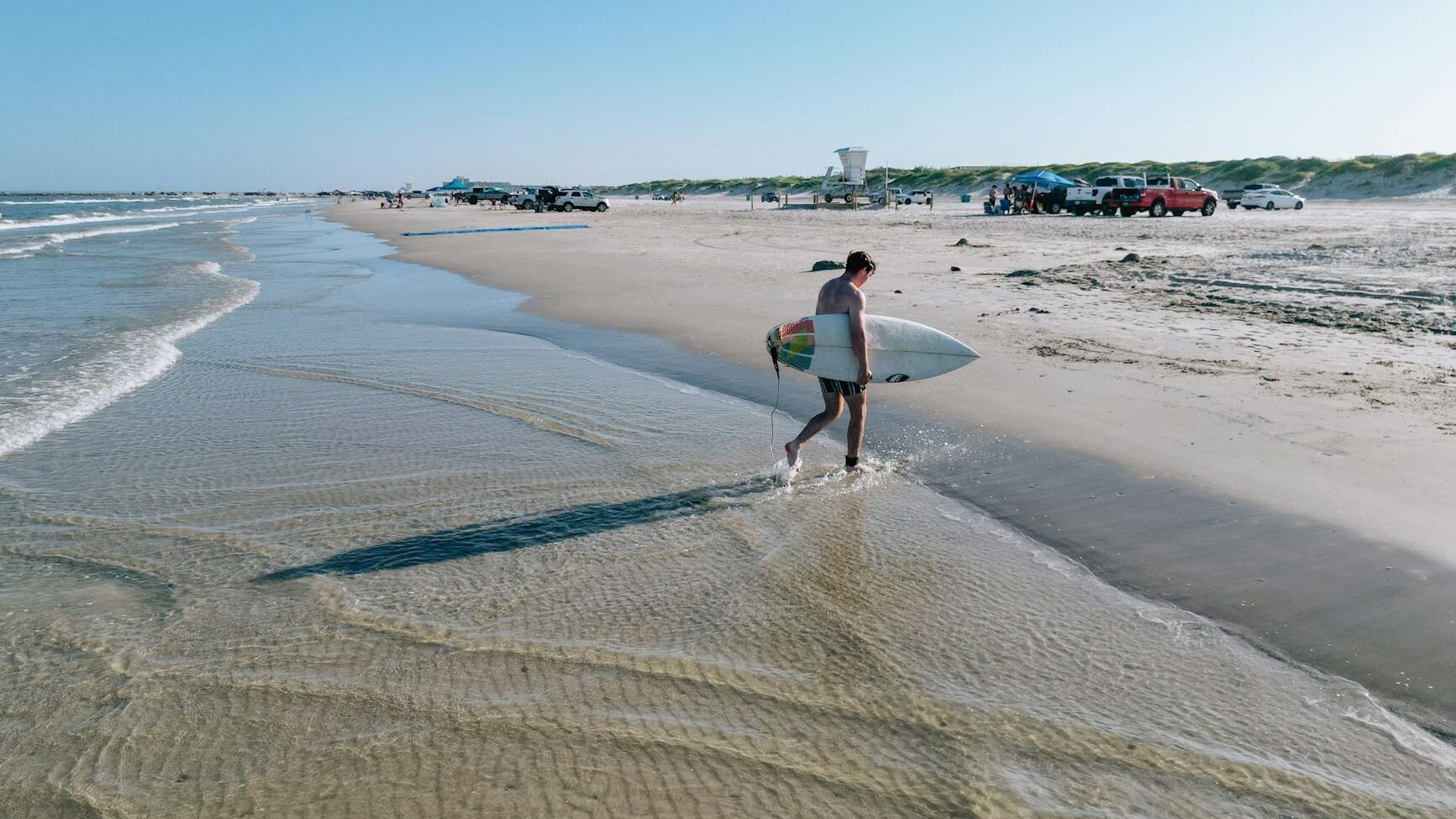 surfer walking on padre island beach