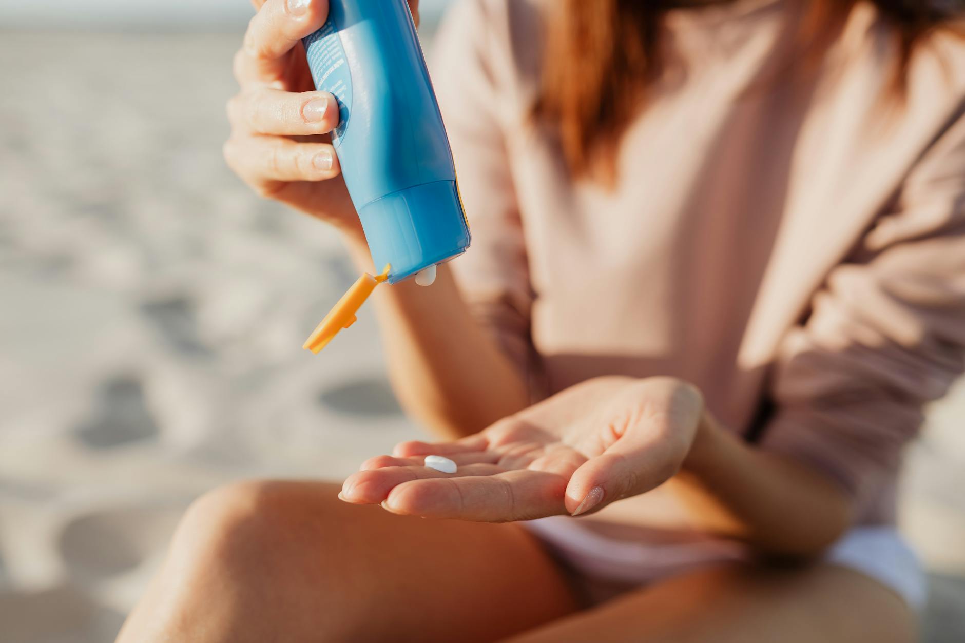 woman putting sunscreen on her hand | Port Aransas Explorer @portaransastex